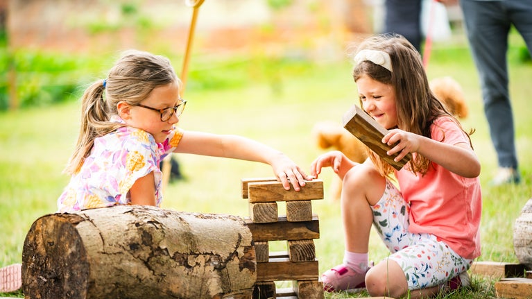 Two girls play Jenga together in the Walled Garden at Ickworth